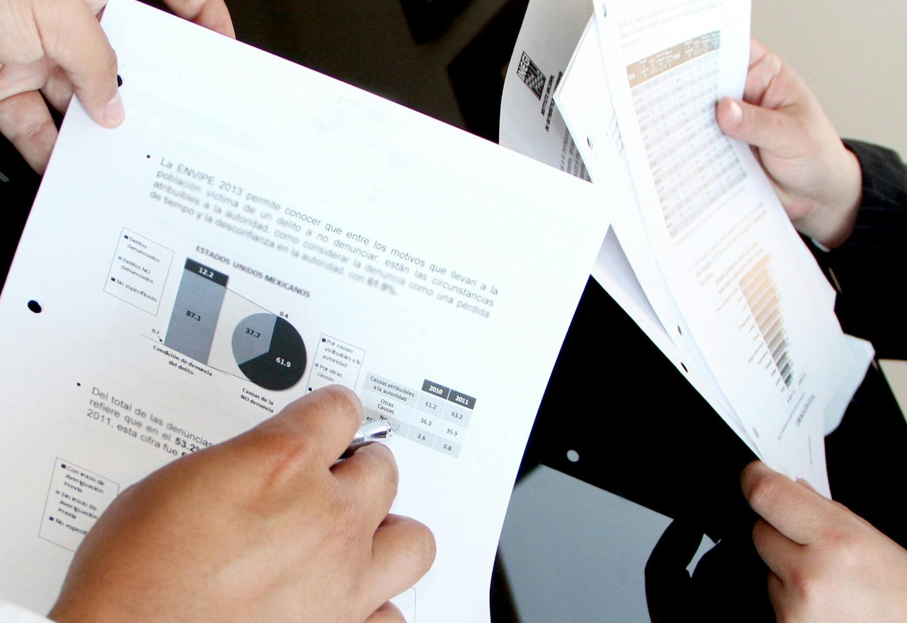 A business team reviewing charts and graphs on documents, emphasizing data analysis and teamwork.